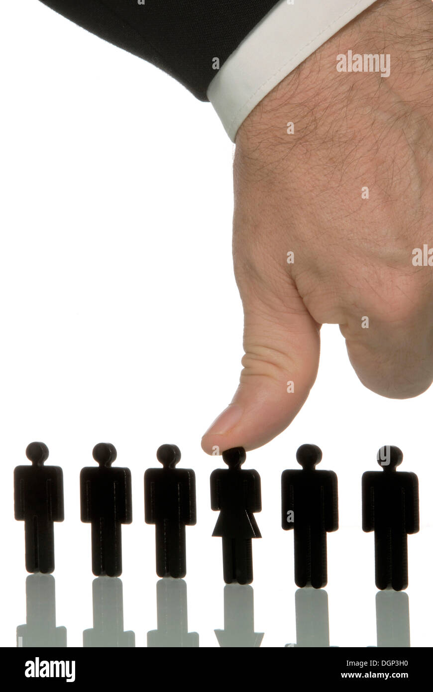 Businessman pushing down female figure with his thumb amidst a series of male figures, symbolic image for discrimination against Stock Photo
