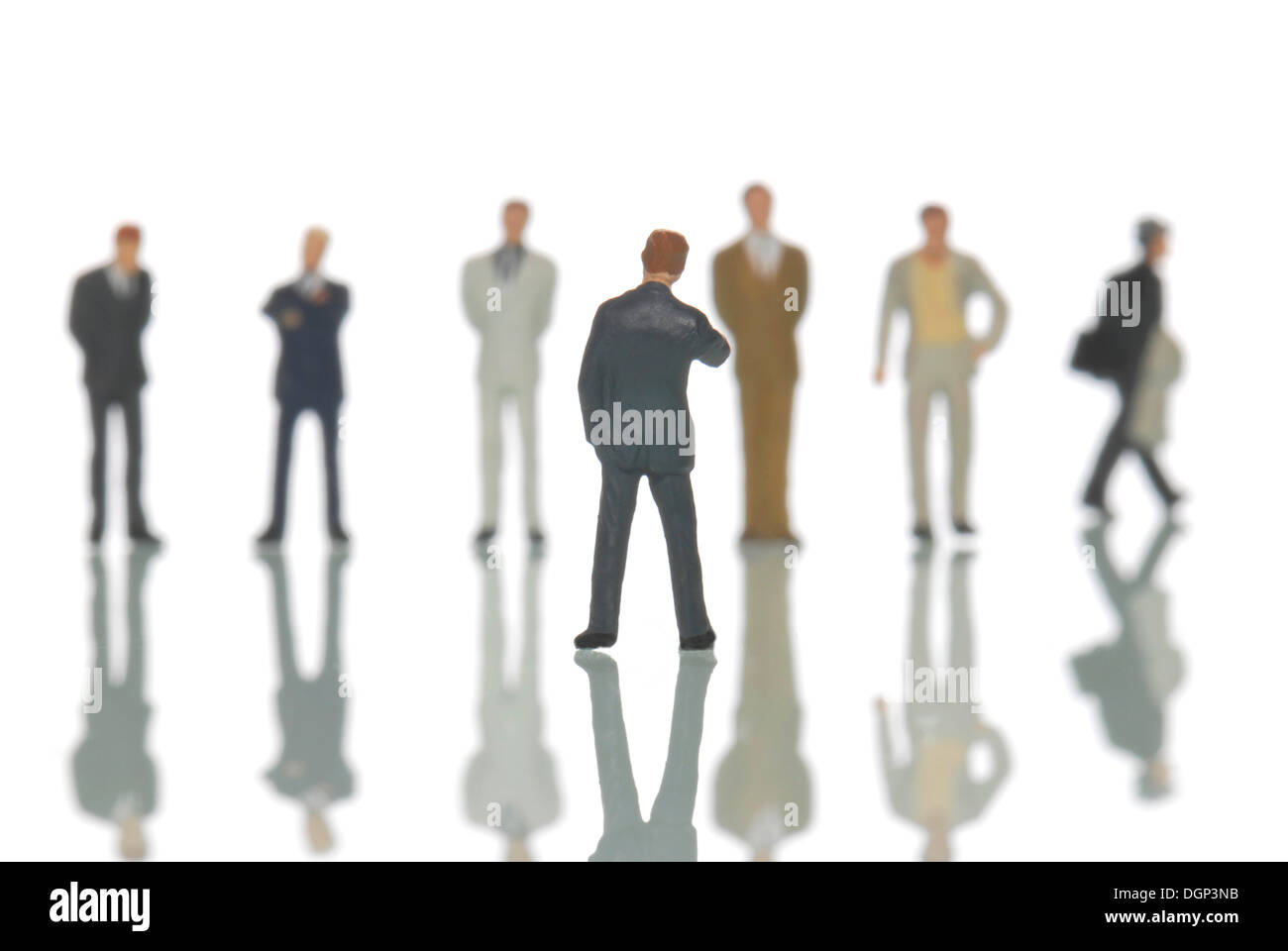Number of businesmann model figures behind a single model figure, symbolic image for a job interview Stock Photo