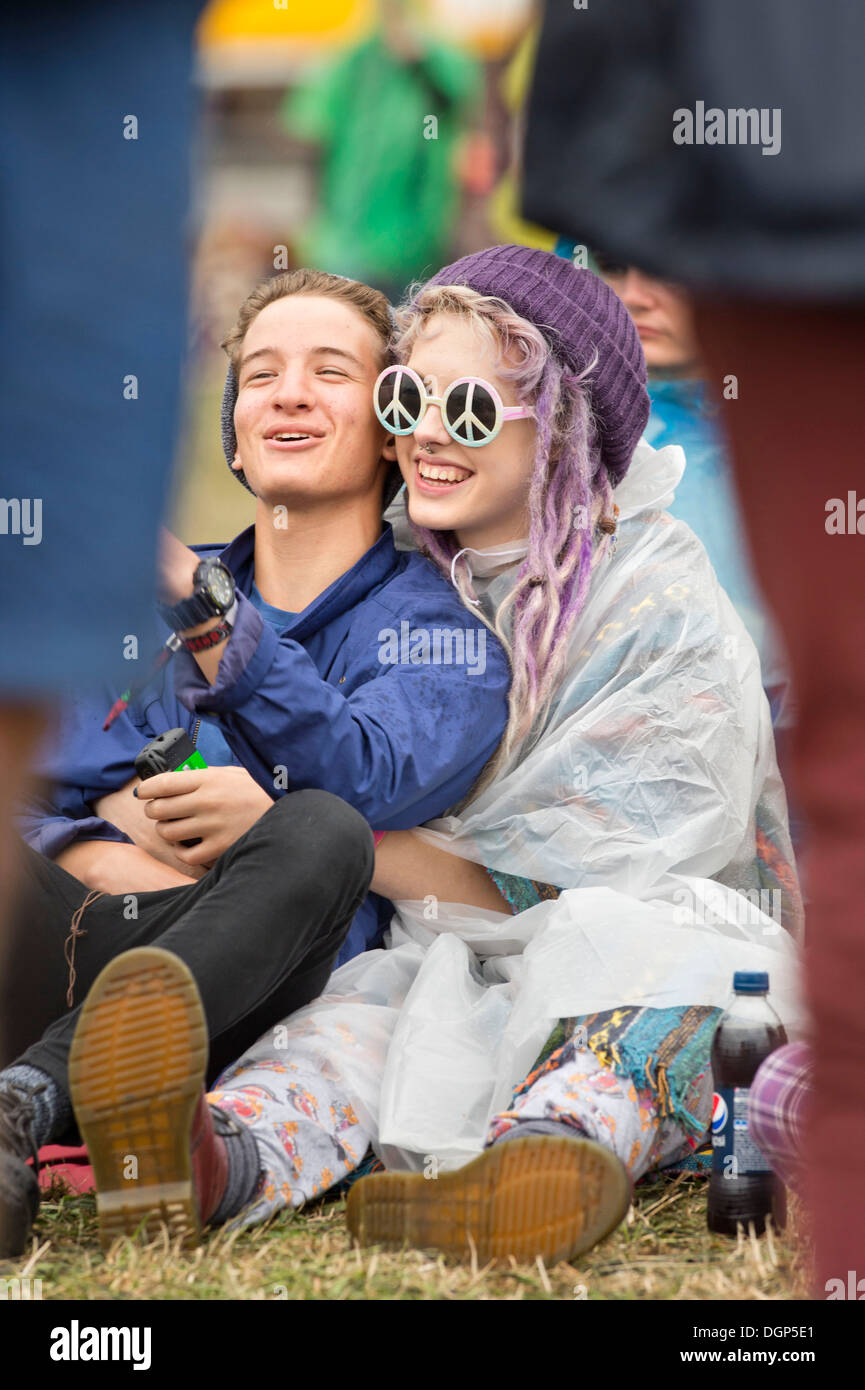 The Reading Festival - a girl in a plastic poncho with CND sunglasses Aug 2013 Stock Photo