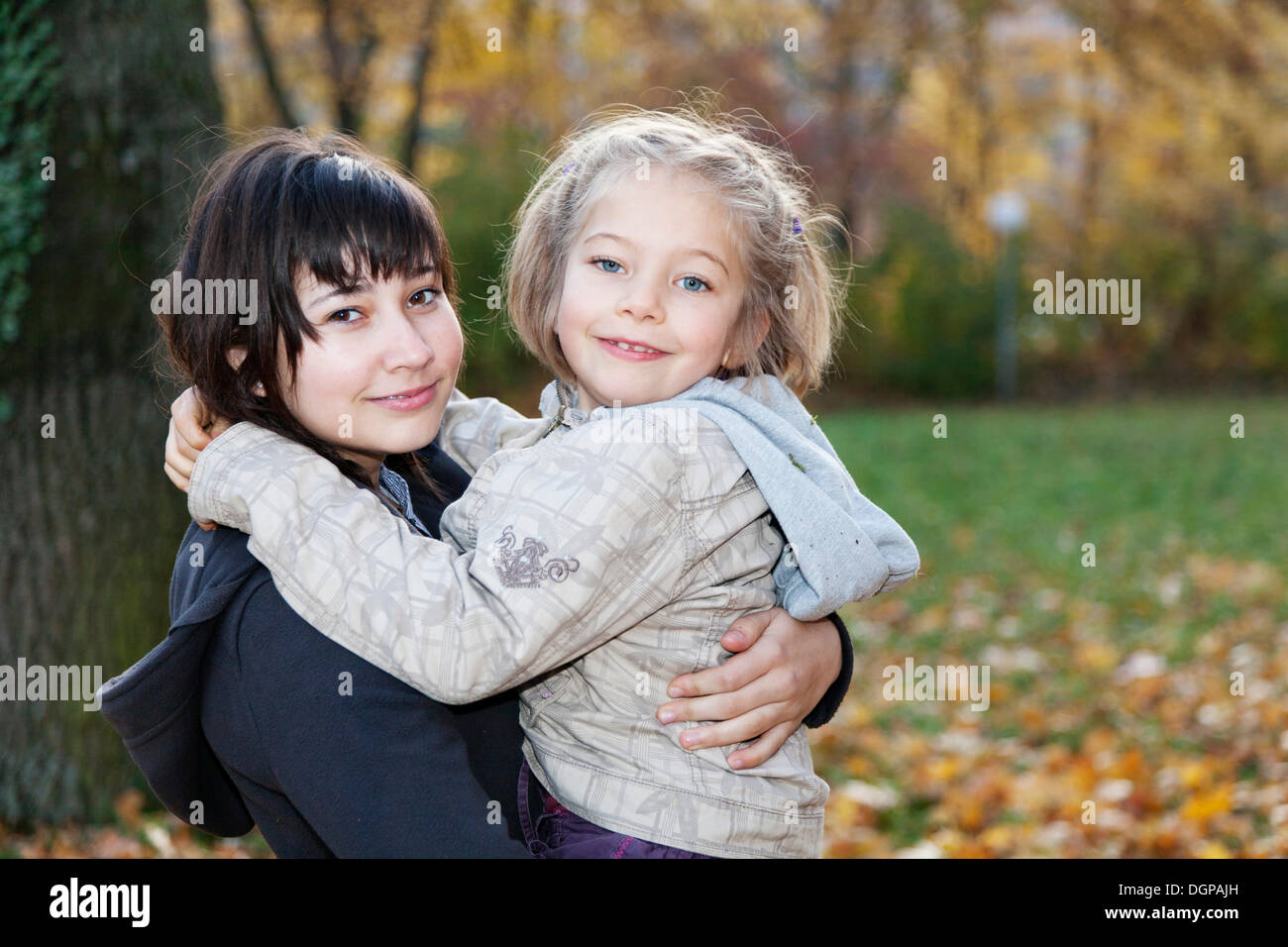 Teenage girl, 14 years, holding girl, 6 years, in her arms Stock Photo