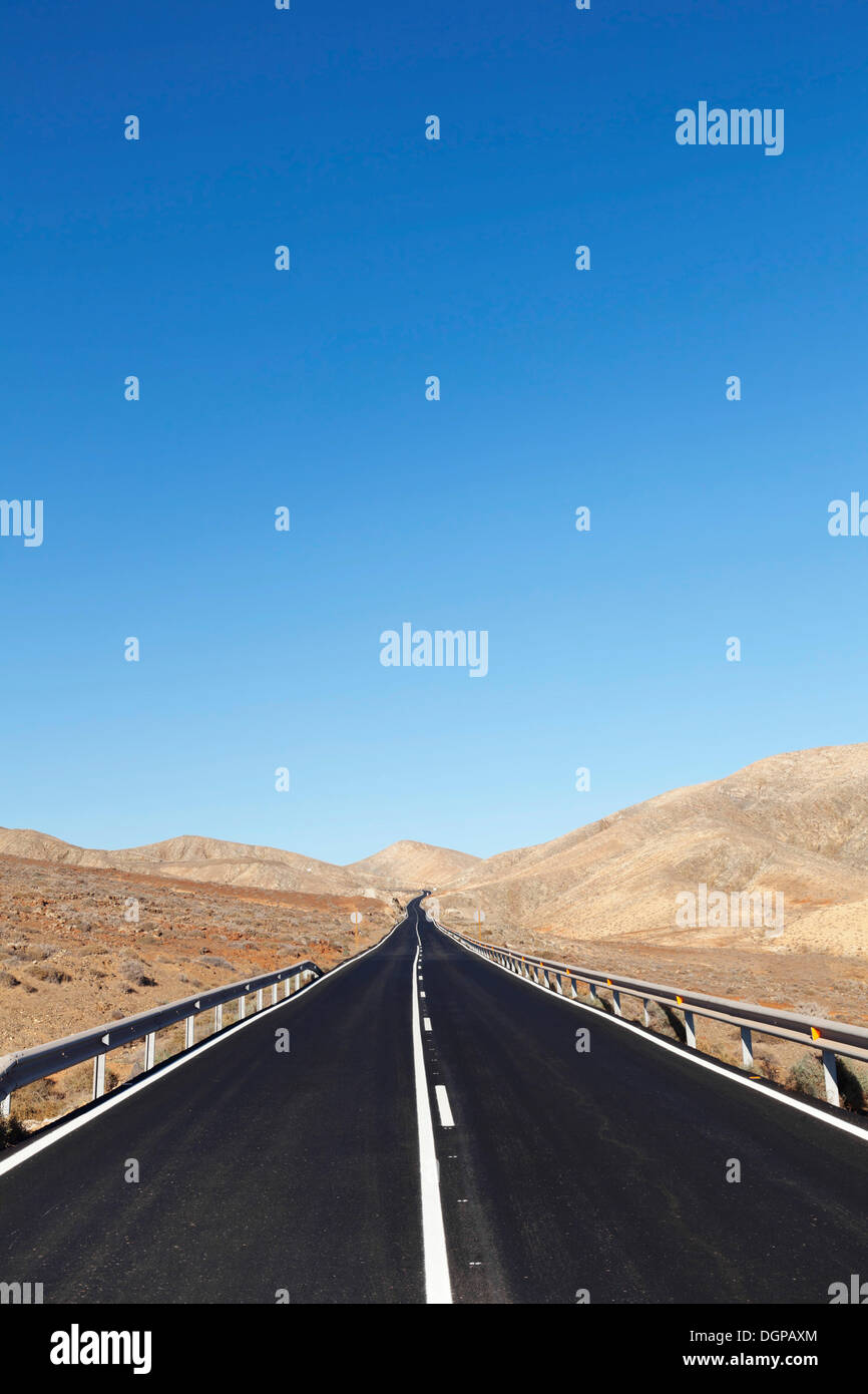 Road through a barren mountain landscape, nahe Pajara, Fuerteventura, Canary Islands, Spain Stock Photo