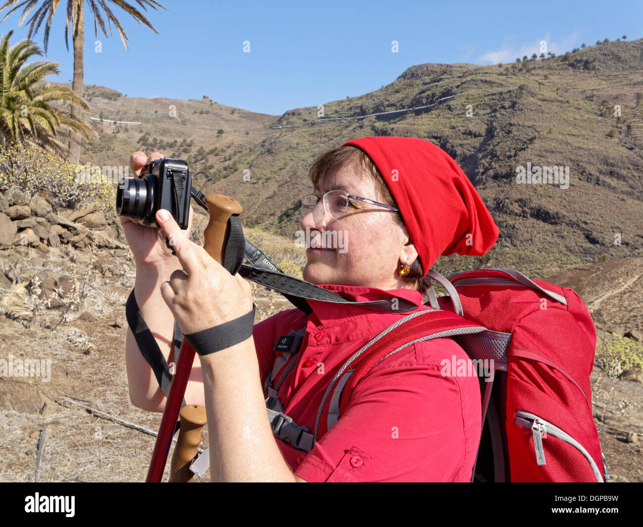 Female hiker taking a picture with a small digital camera, Barranco de la Guancha, La Gomera, Canary Islands, Spain, Europe Stock Photo