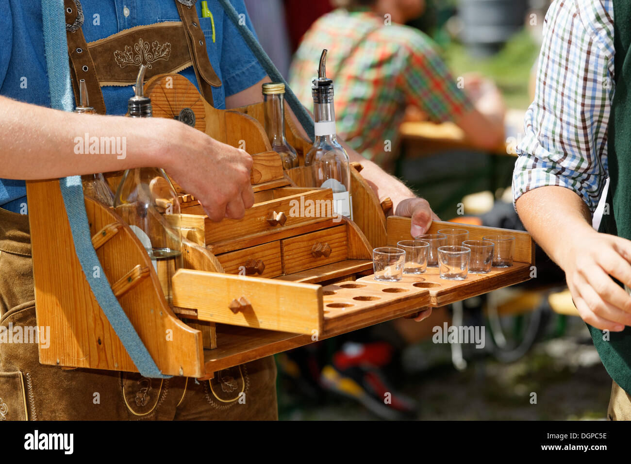 Man with a hawker's tray selling liquor, Pfeifertag festival on Niedergadenalm alp, Strobl, Salzburg state Stock Photo