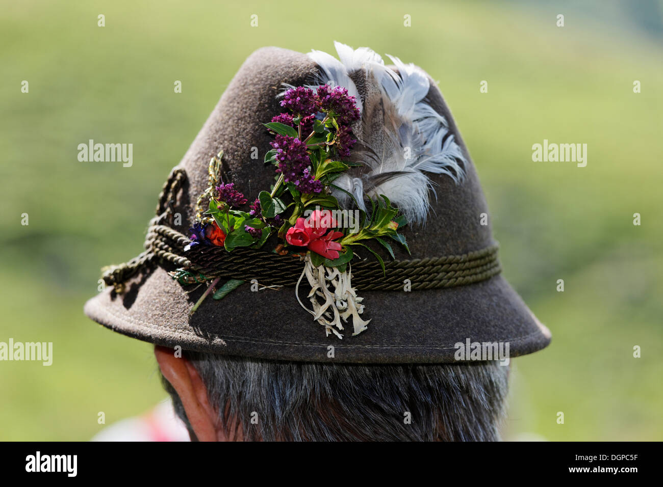 Man wearing a hat decorated with flowers, Pfeifertag festival on Niedergadenalm alp, Strobl, Salzburg state Stock Photo