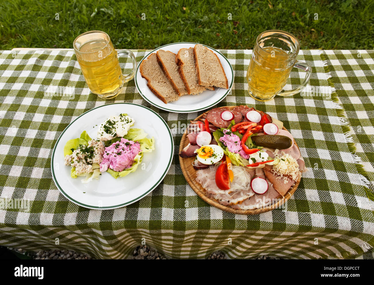 A sausage and cheese platter and some spread on a plate with two glasses of cider, young wine, near Gruenberg, Pyhrn-Eisenwurzen Stock Photo