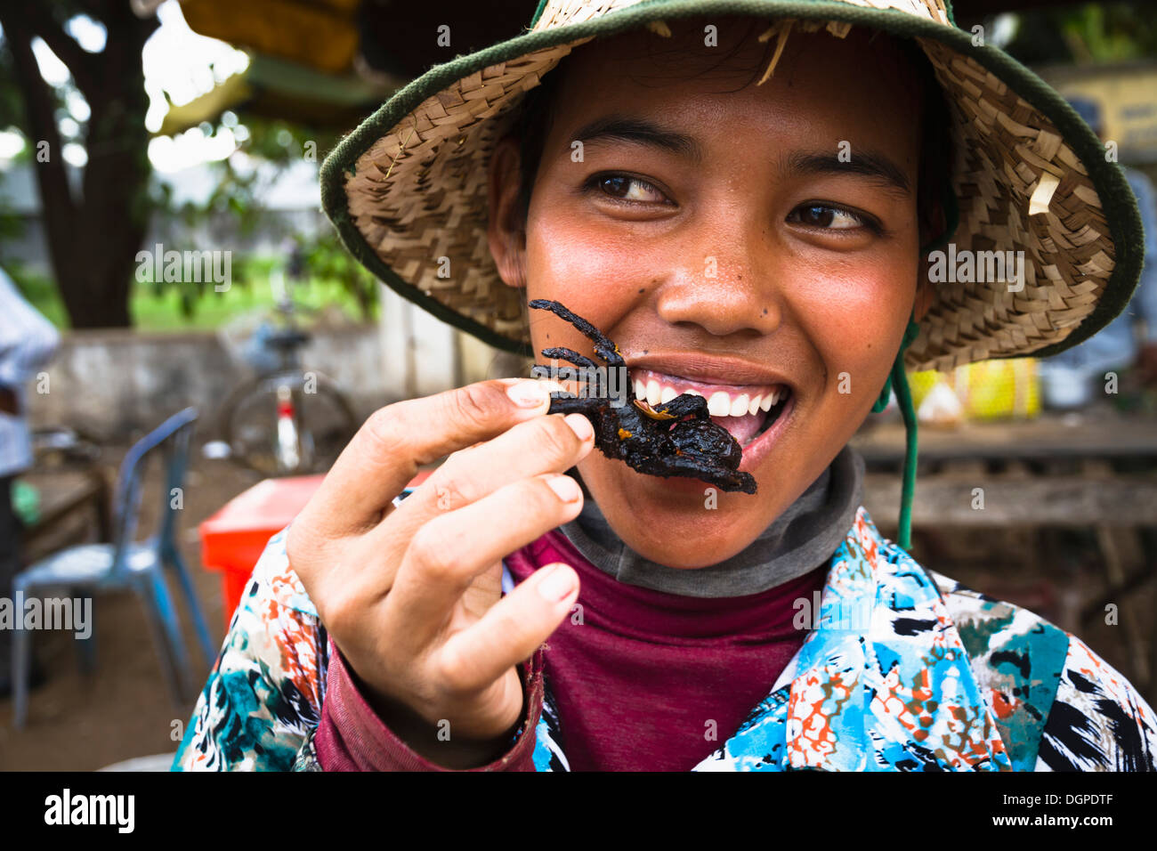 Cambodia, Woman eating fried tarantula spiders Stock Photo