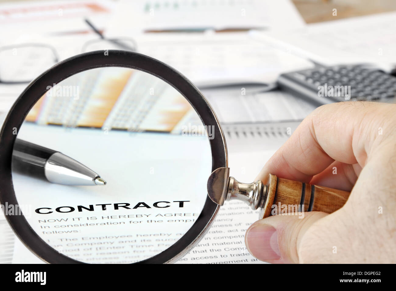 Magnifying Glass Over Contract Papers Stock Photo