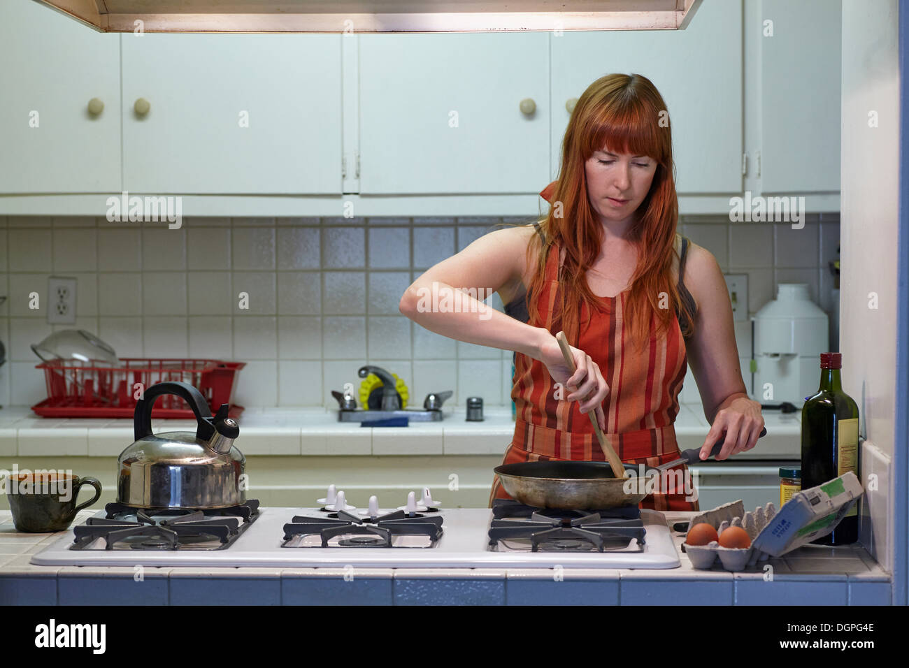 Mid adult woman cooking in kitchen Stock Photo
