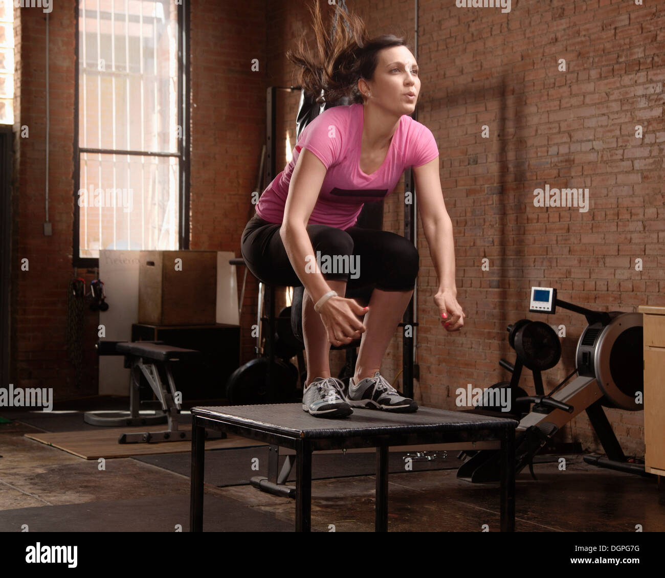 Young woman jumping on table in gym Stock Photo Alamy