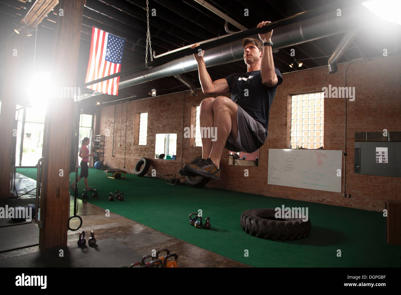 Bodybuilder doing pull up on bar in gym Stock Photo