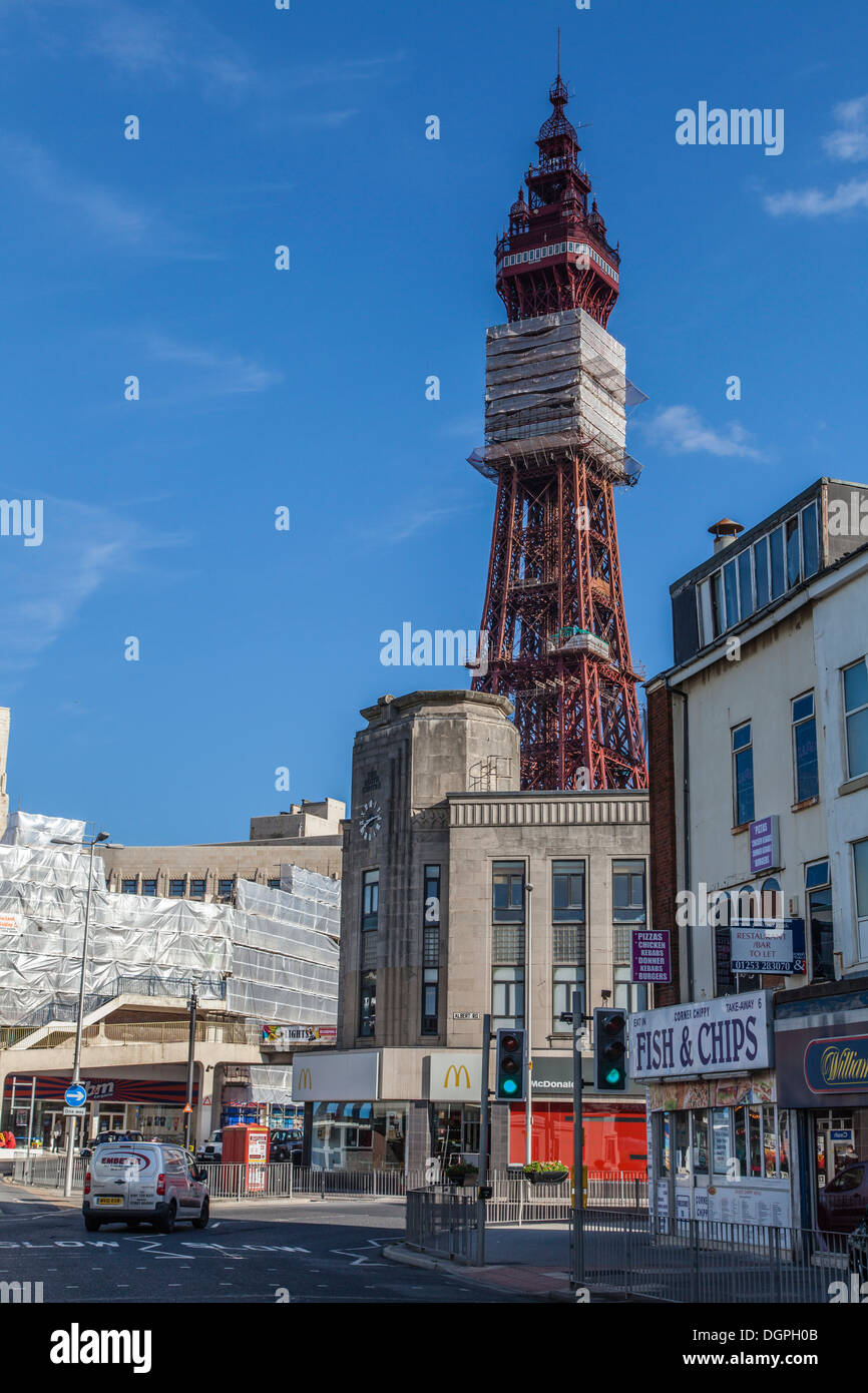 Blackpool street with only a car in it, Fish and Chip shop in the foreground and the Blackpool Tower in the distance. Stock Photo