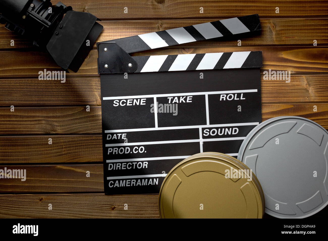 top view of clapper board with movie light and film reels on wooden table Stock Photo