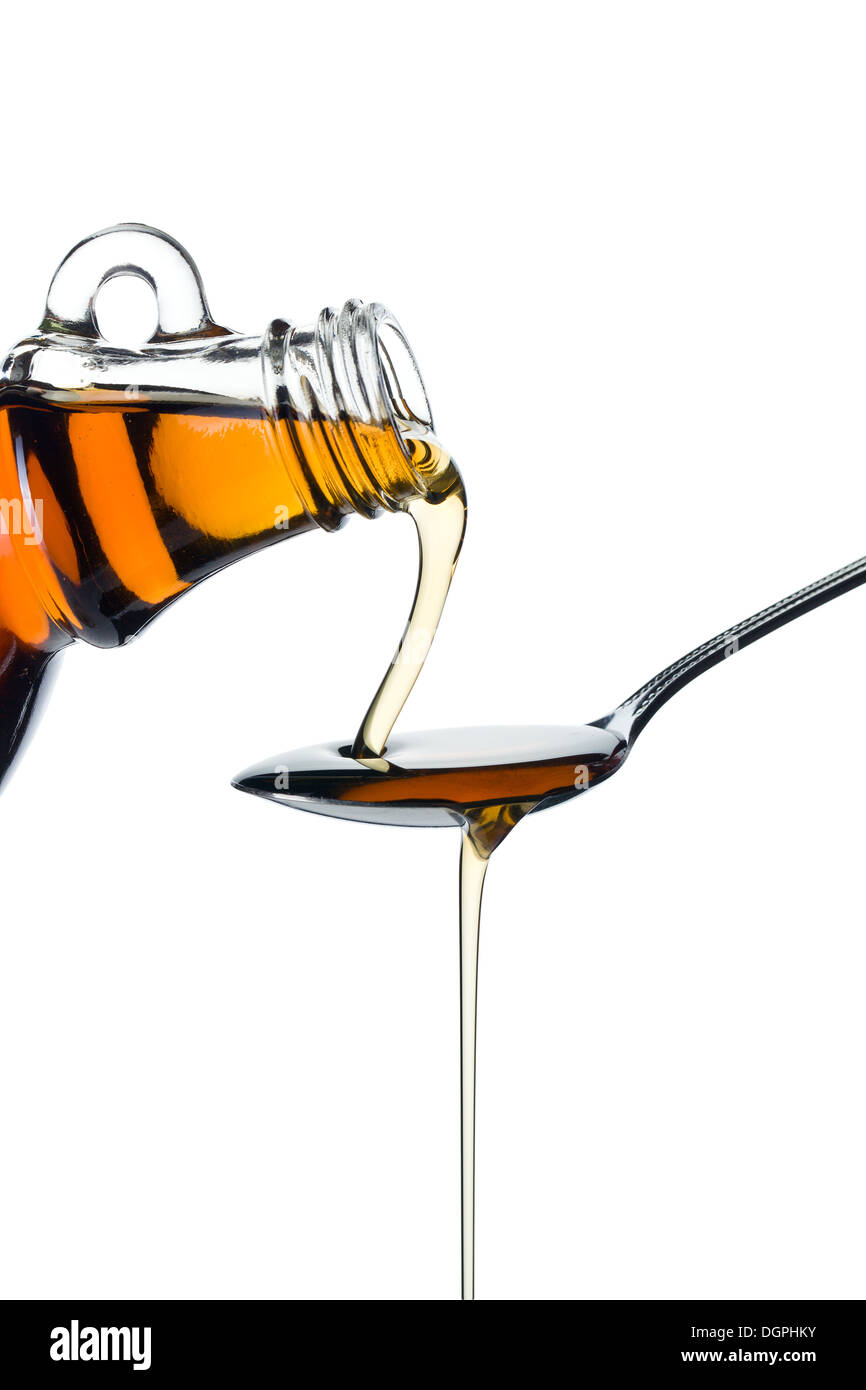 maple syrup pourin on spoon on white background Stock Photo