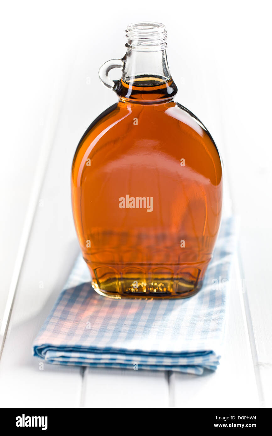 maple syrup in glass bottle on white wooden table Stock Photo