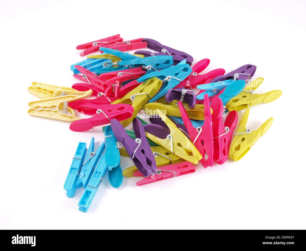 Multicolored plastic clothes pegs on a white background. Stock Photo