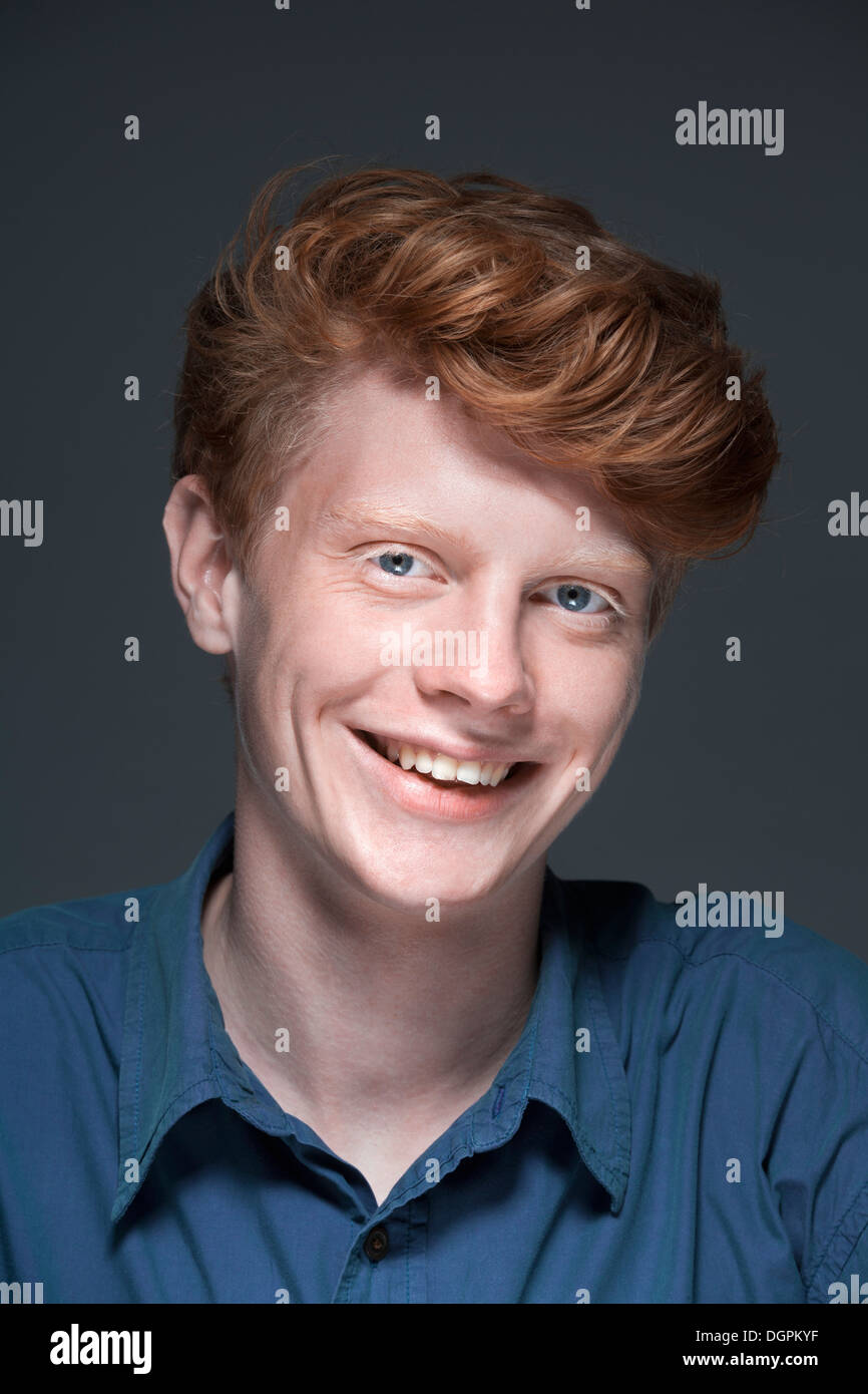 Portrait of young man against grey background, smiling Stock Photo - Alamy