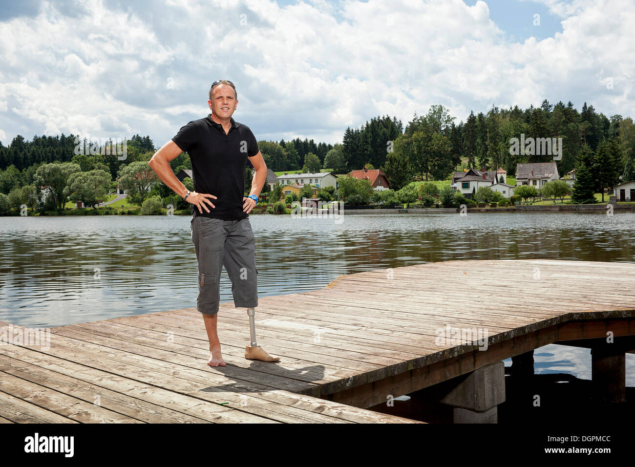 Man with a prosthetic leg standing on a jetty Stock Photo