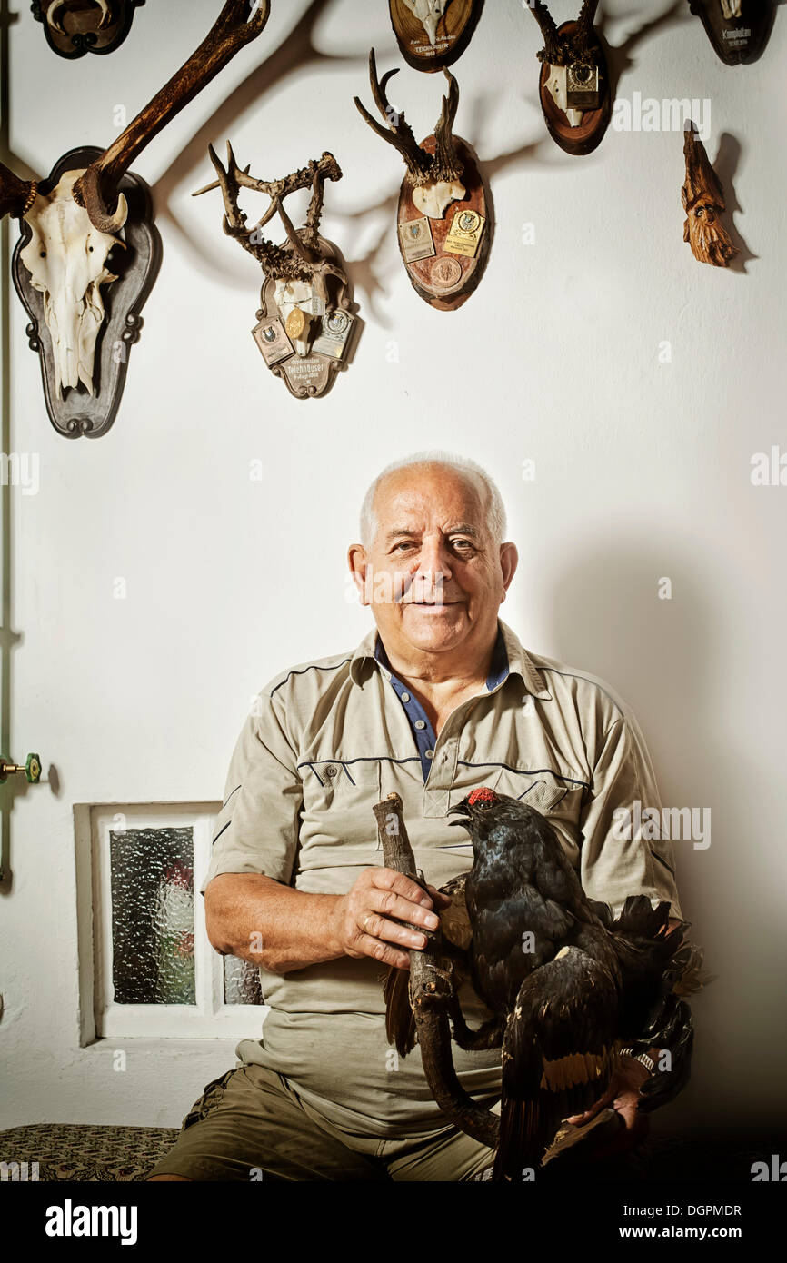 Old man with his collection of hunting trophies Stock Photo