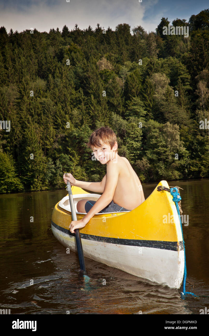 Boy paddling in a canoe Stock Photo