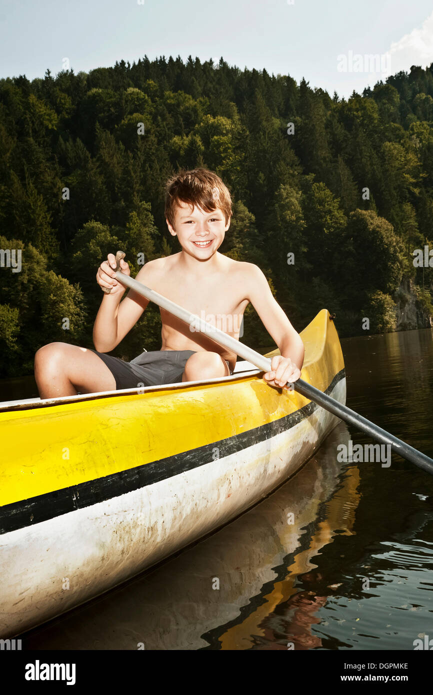 Boy paddling in a canoe Stock Photo Alamy