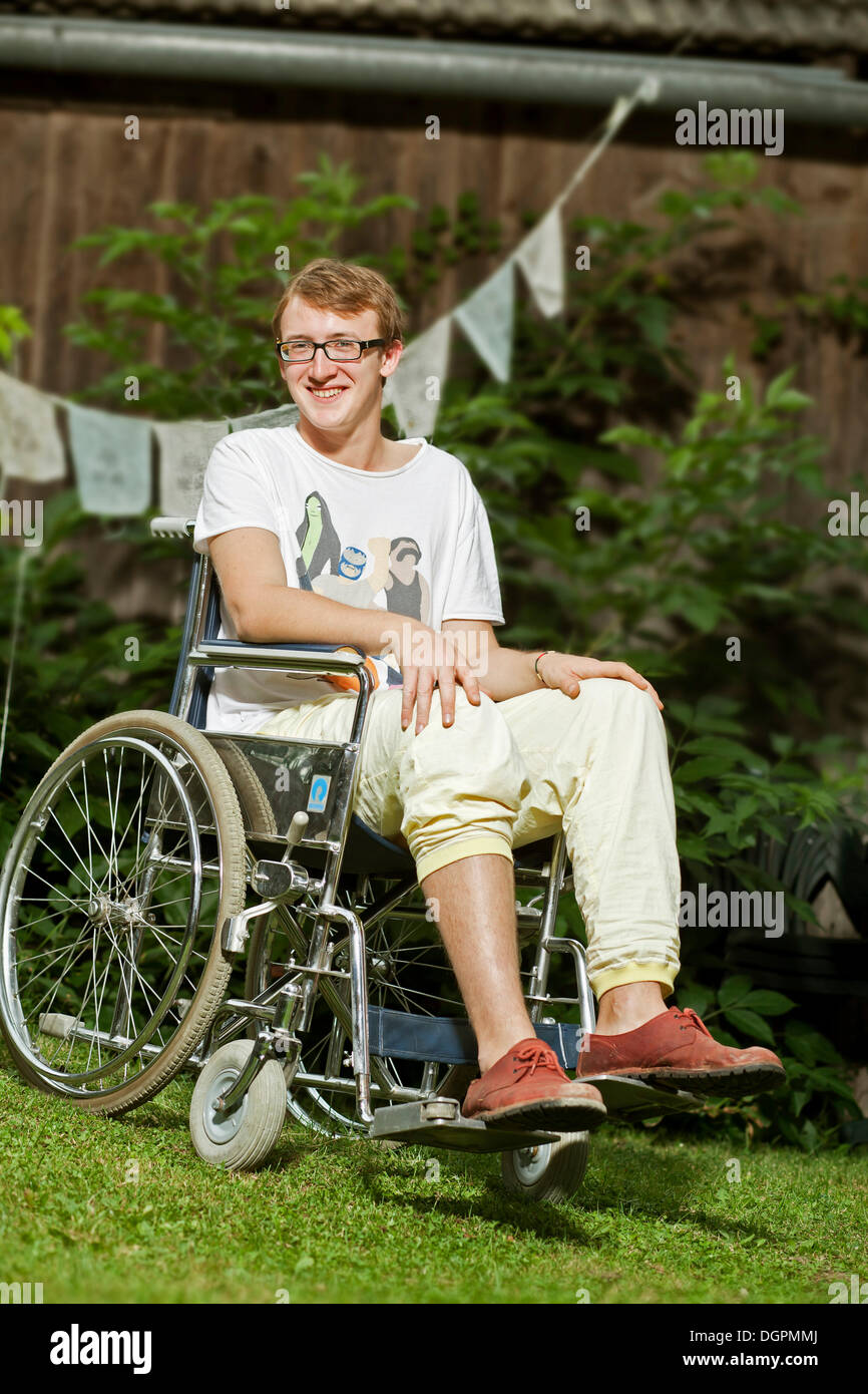 Teenager sitting in a wheelchair Stock Photo - Alamy
