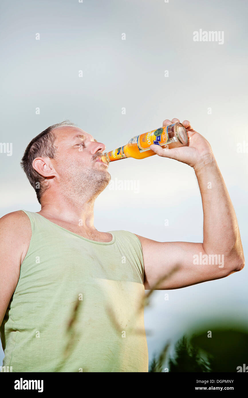 Man drinking a soft drink from the bottle Stock Photo