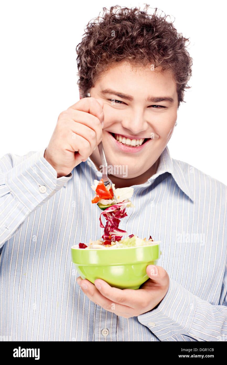 Happy young chubby man with fresh salad in dish, isolate on white Stock Photo