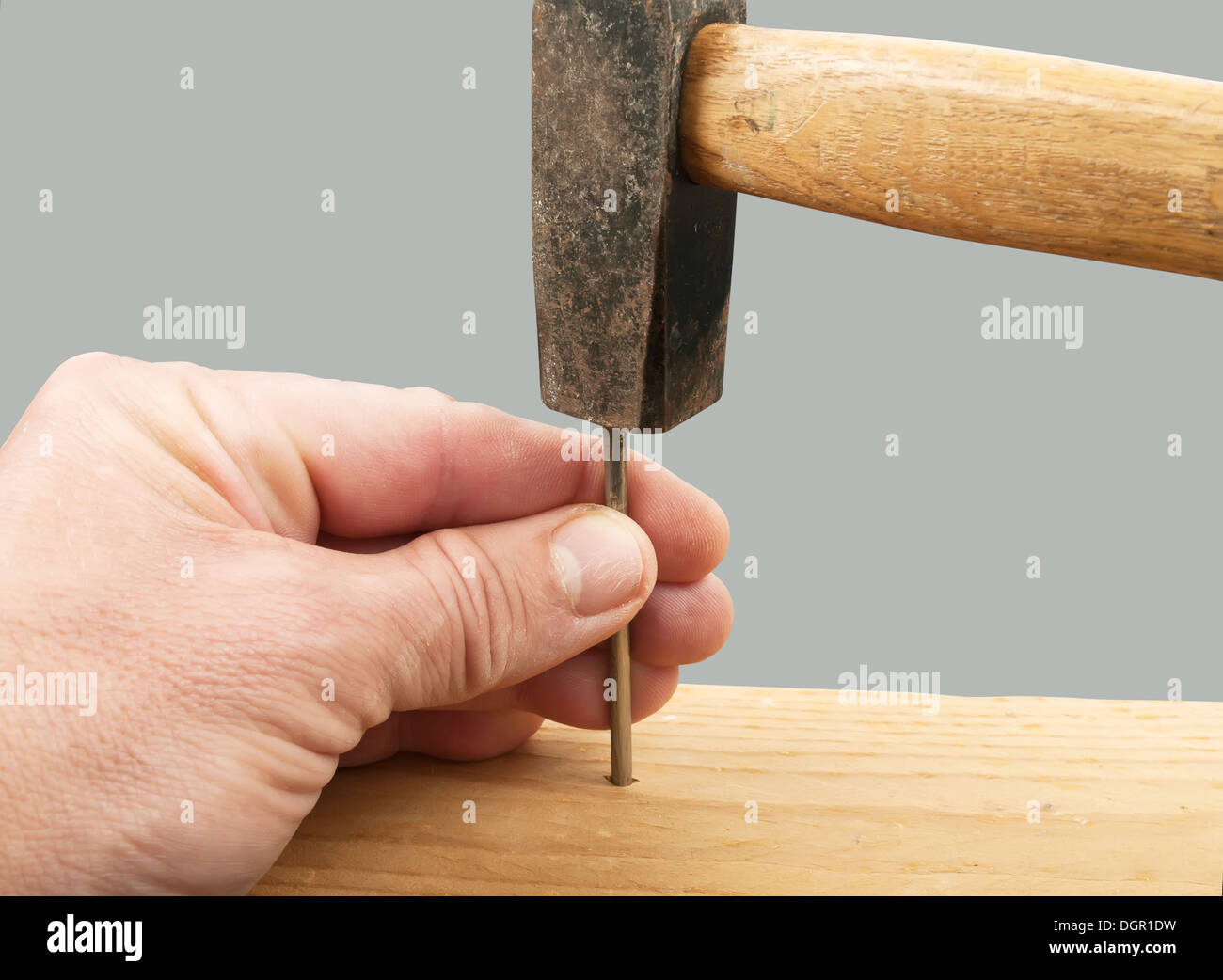 hands with hammer hitting a nail Stock Photo