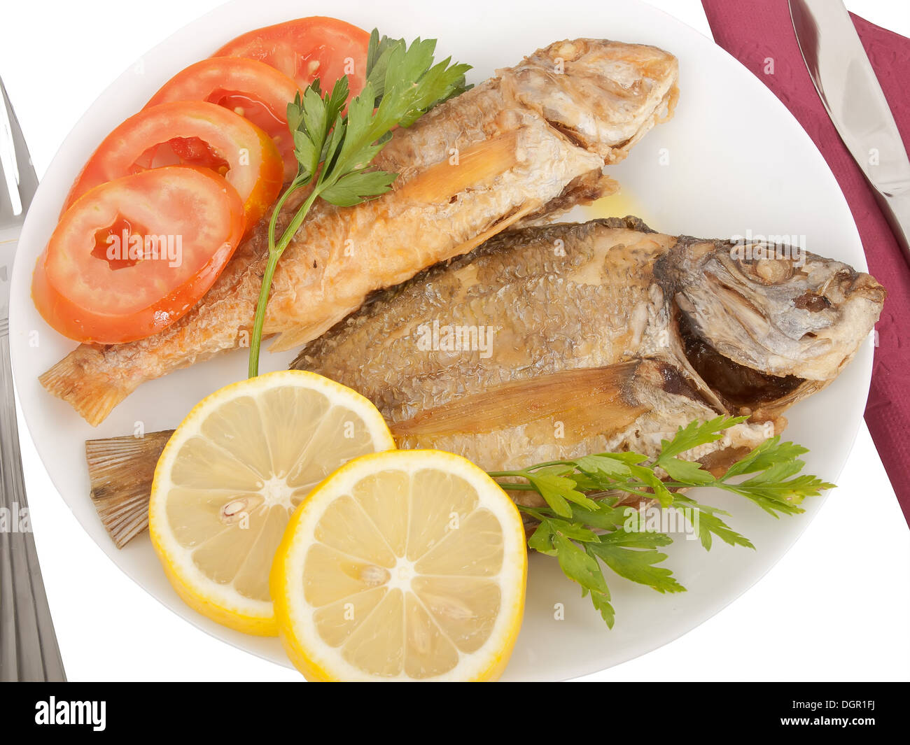 diplodus puntazzo and mullus surmuletus delicious grilled fishes with sliced tomato, lemon and parsley; all in olive oil Stock Photo