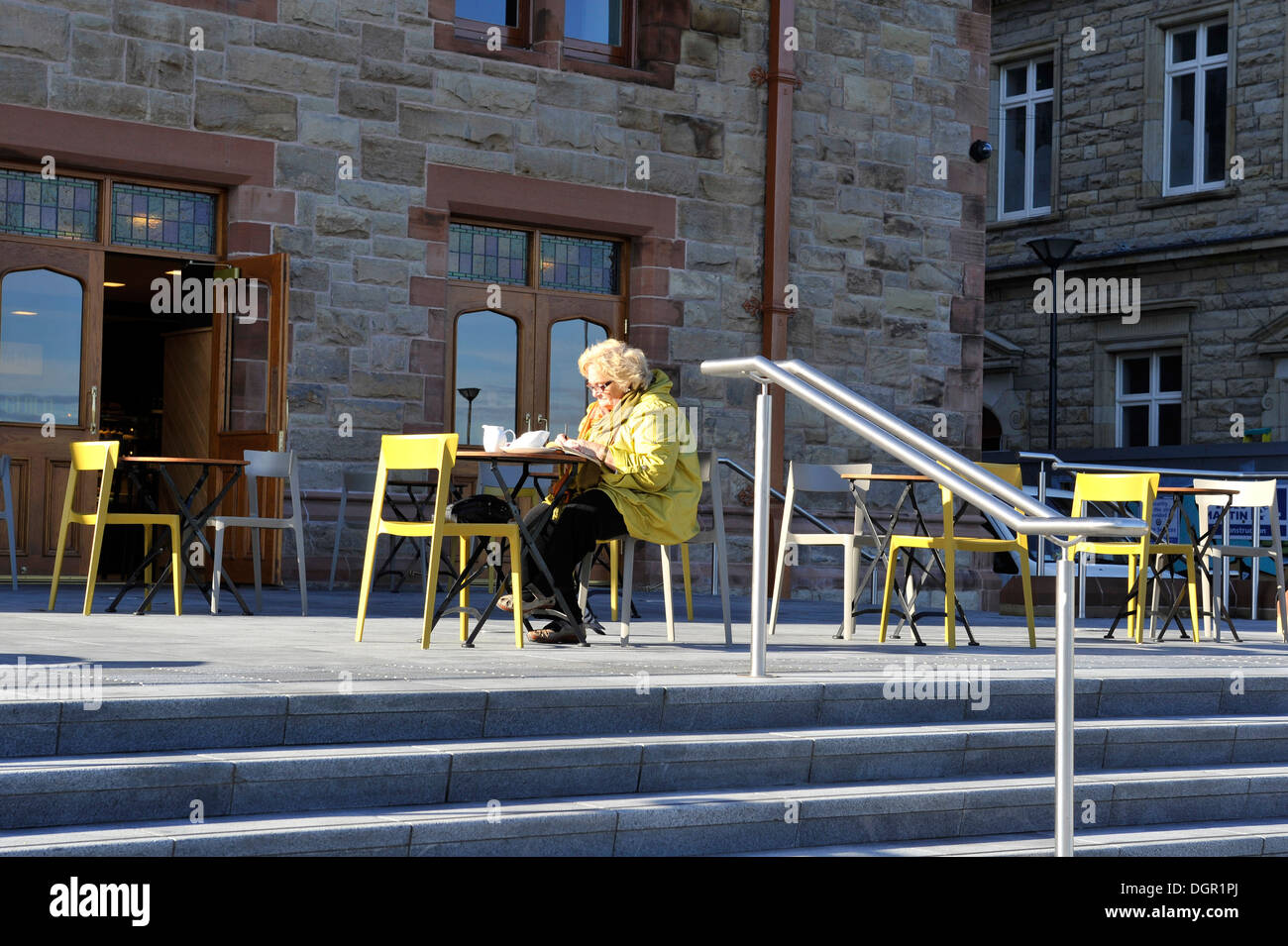 Elderly lady having tea alone at outdoor café table, Derry, Londonderry, Northern Ireland, UK Stock Photo