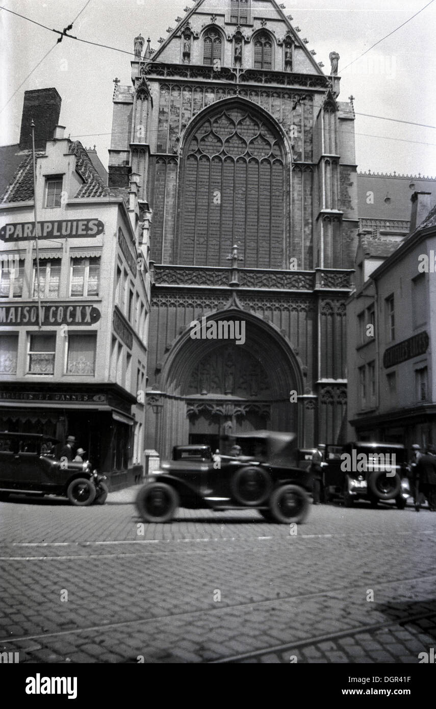1930s, historical view Antwerp, Belgium, showing cobbled street, church and motorised vehicles of the day. Stock Photo