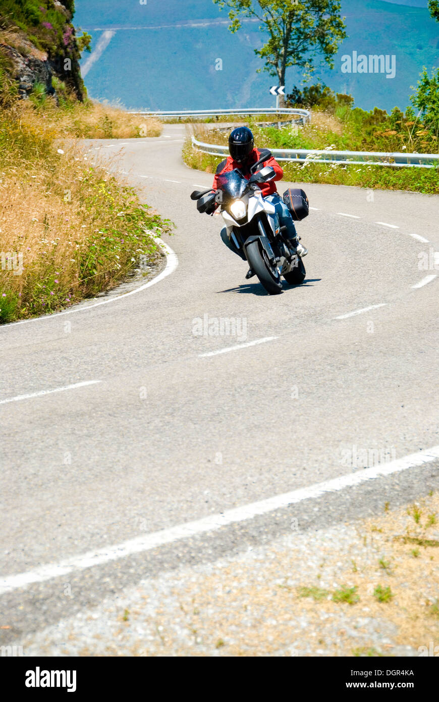 A motorcyclist comes around the bend Stock Photo