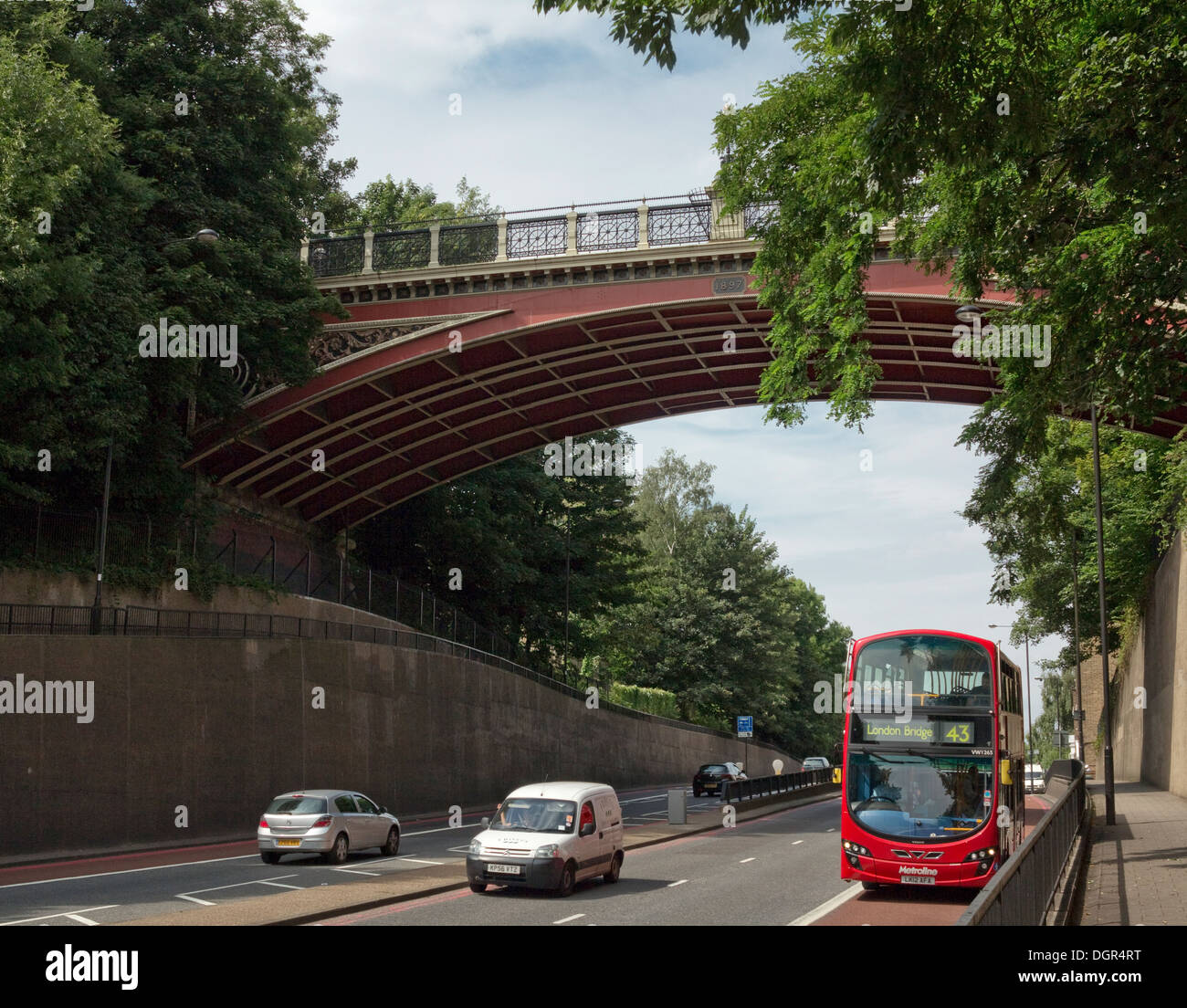 Red bus on Archway Road, north London, passes beneath bridge, popularly known as Suicide Bridge, due to people who have thrown themselves from bridge Stock Photo