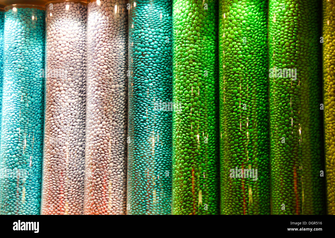 Multi coloured sweets in tall glass jar display Stock Photo
