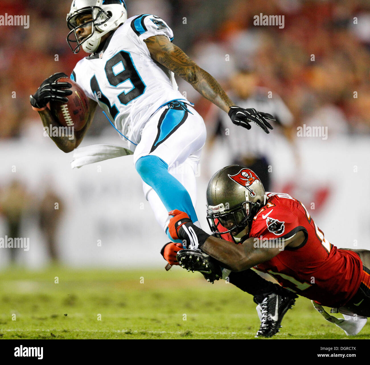 Tampa, Florida, USA. 24th Oct, 2013. Carolina Panthers wide receiver TED GINN (19) gets dragged down by Tampa Bay Buccaneers defensive back MICHAEL ADAMS (21) on a kickoff return in the first quarter at Raymond James Stadium. © Will Vragovic/Tampa Bay Times/ZUMAPRESS.com/Alamy Live News Stock Photo
