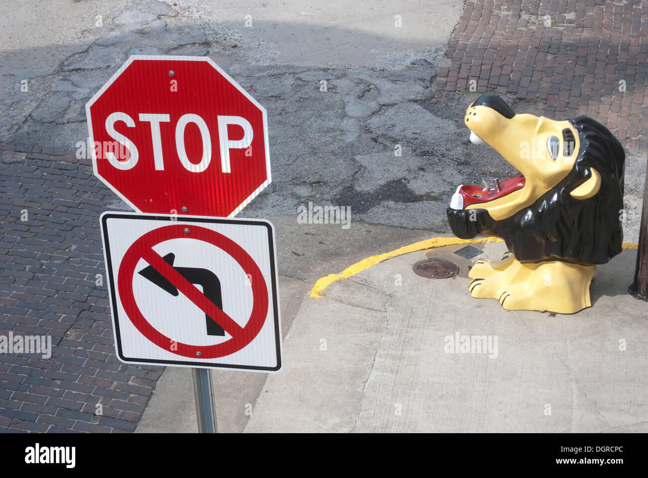 A street corner in Oakland, Illinois on which stands a Lions Club dedicated water fountain, no left turn sign and a stop sign Stock Photo