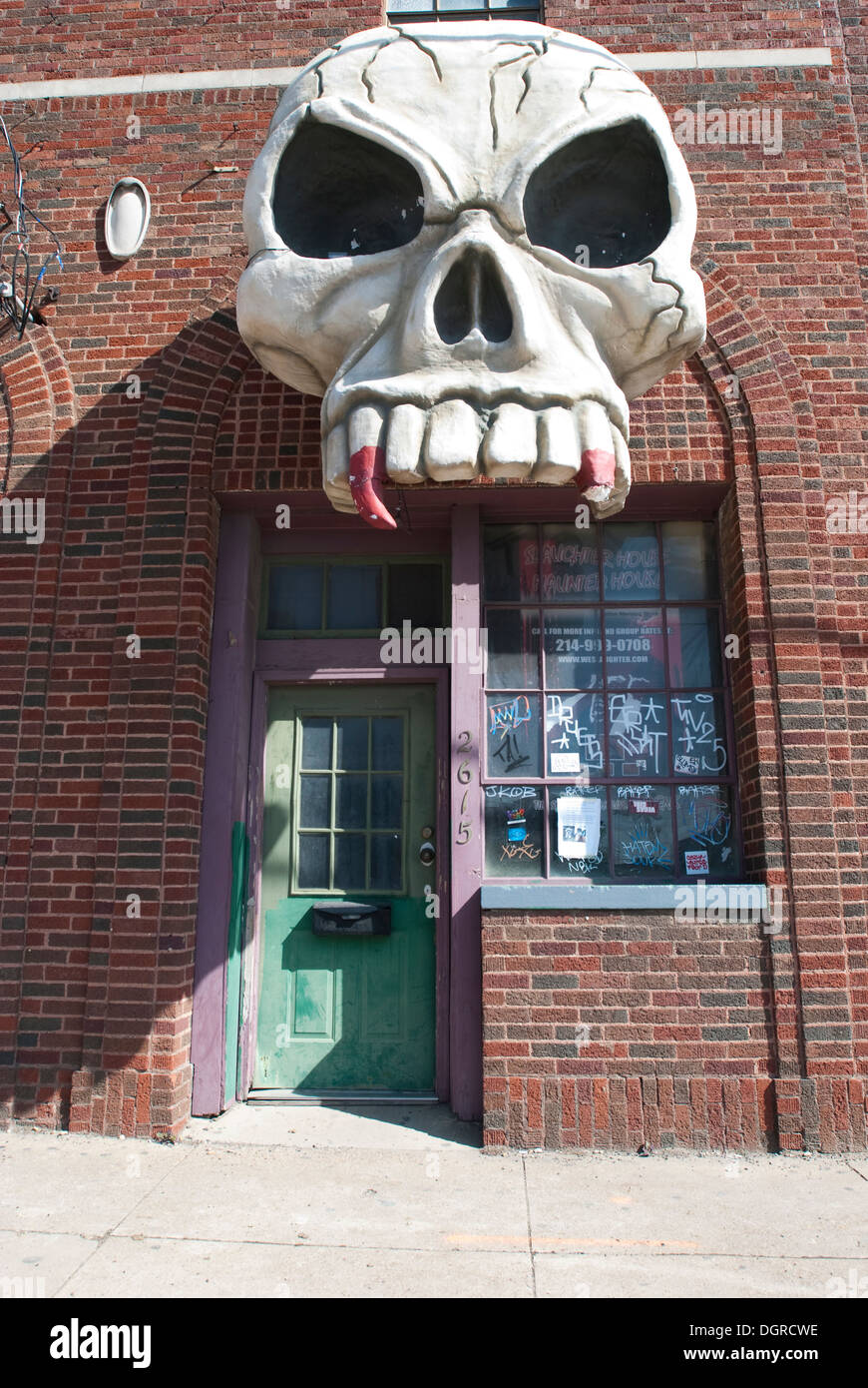 Giant Skull above the entrance to a haunted house set in a warehouse district. Stock Photo