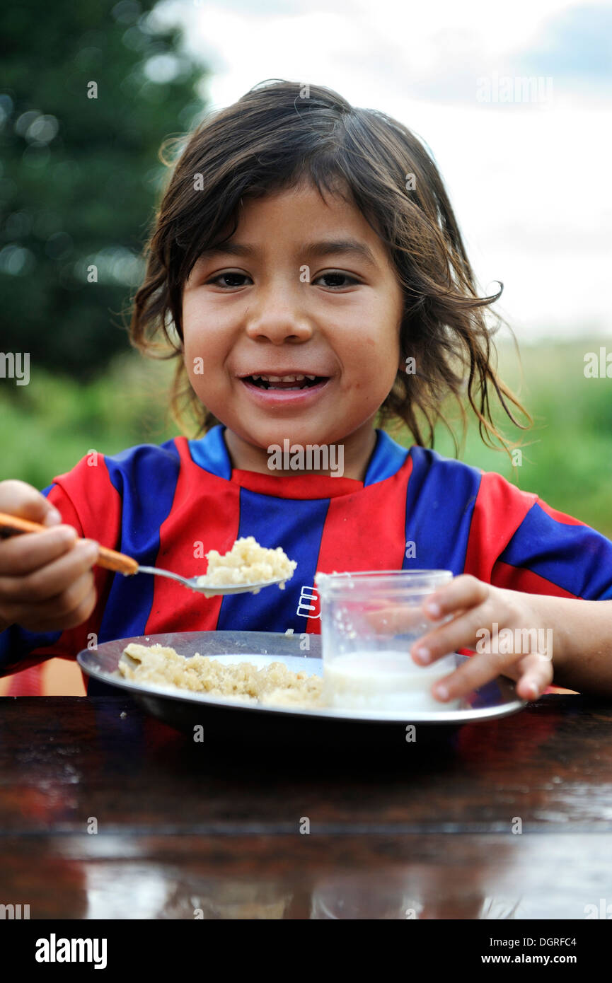 Paraguay, Caaguazu, Jaguary, Guarani girl eating outdoors Stock Photo
