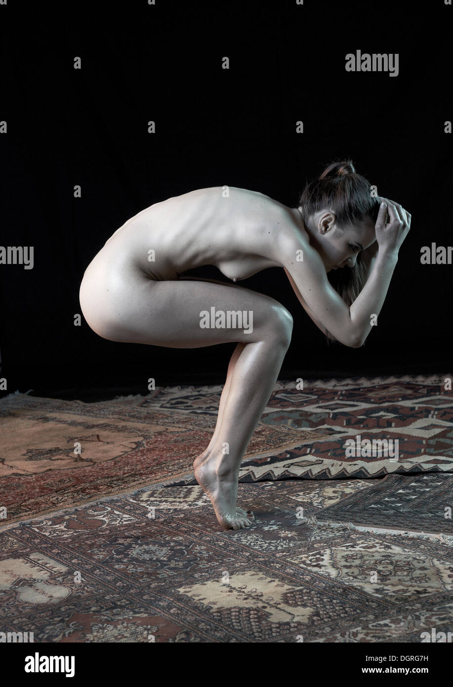 Young woman squatting on tiptoes, yoga pose, nude Stock Photo - Alamy