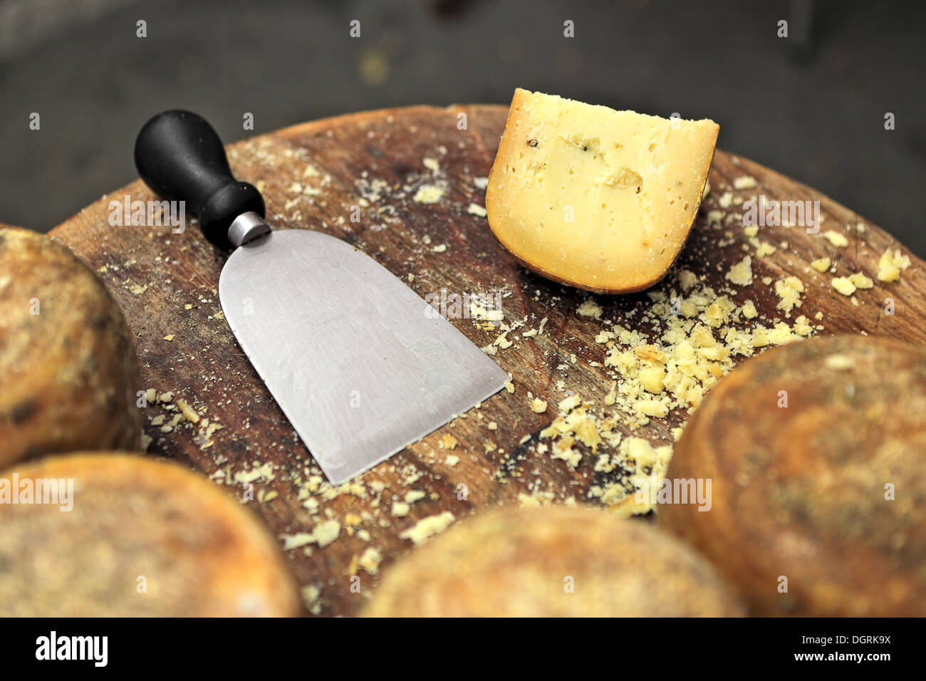 Special knife and famous italian cheese pecorino on small wooden table. Stock Photo