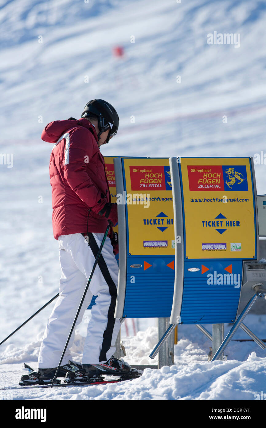 Skier pulling a ticket for the chairlift, Hochfuegen, Zillertal, Austria, Europe Stock Photo