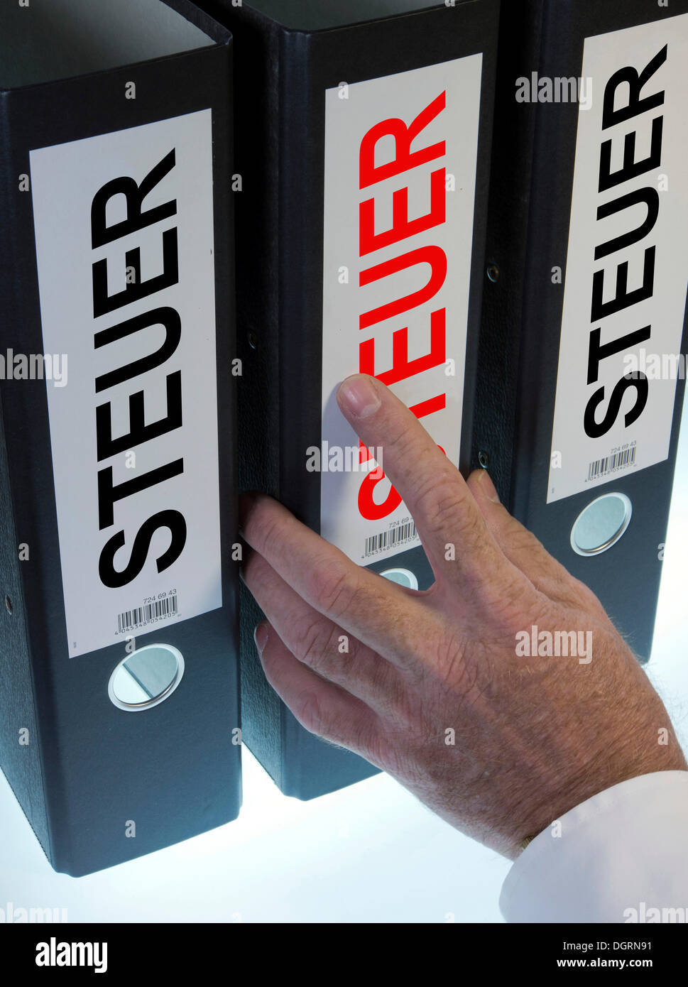 Hand reaching for file folders labeled 'Steuer', German for 'tax' Stock Photo