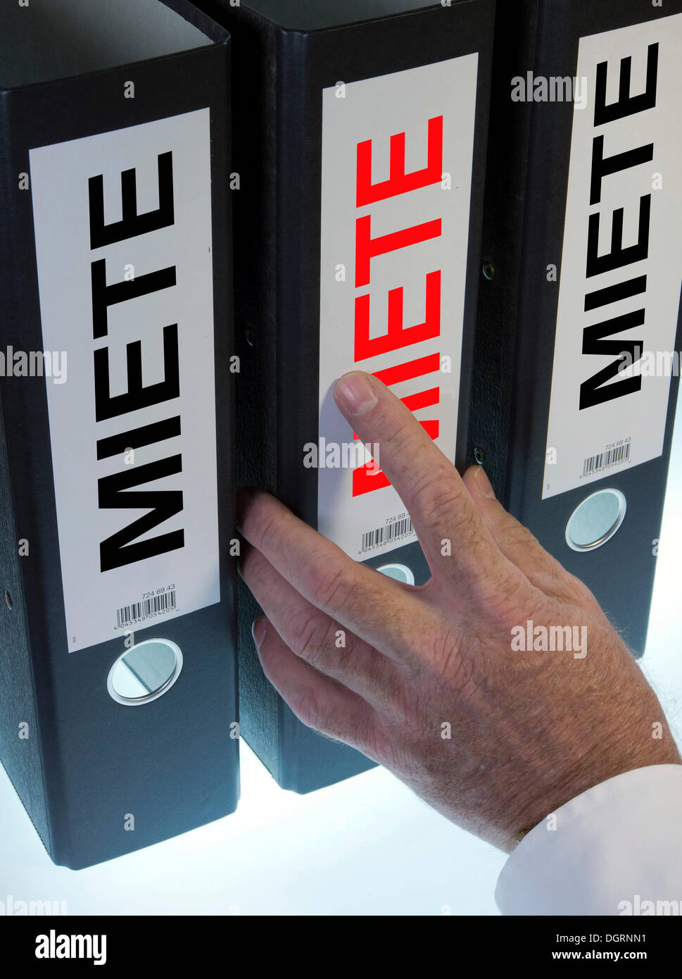 Hand reaching for a file folder labeled 'Miete', German for 'Rent' Stock Photo
