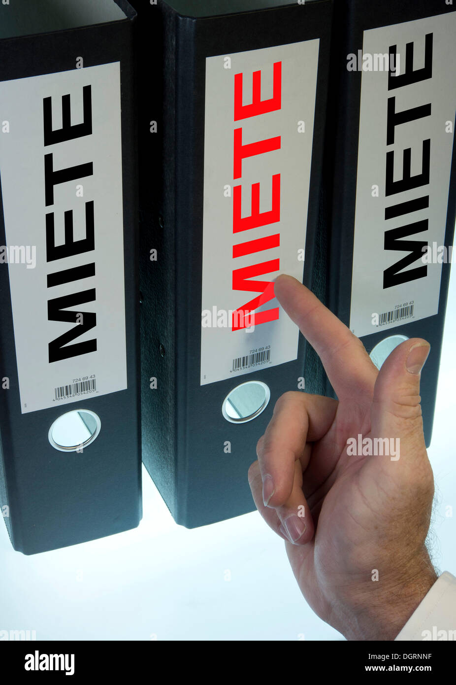 Hand pointing to a file folder labeled 'Miete', German for 'Rent' Stock Photo