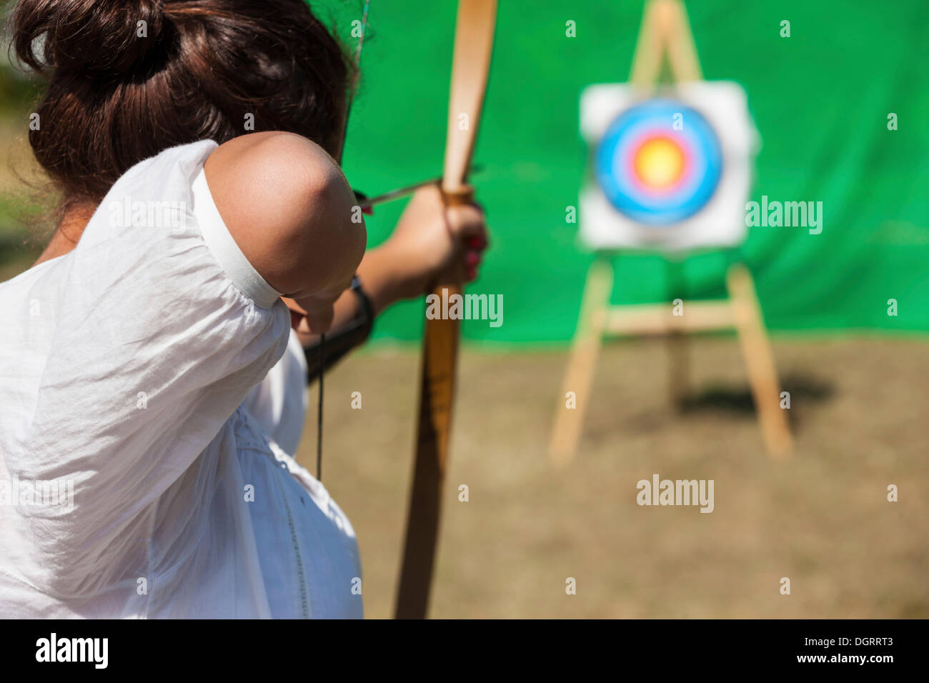Archer aiming bow and arrow at target, Hesse Stock Photo