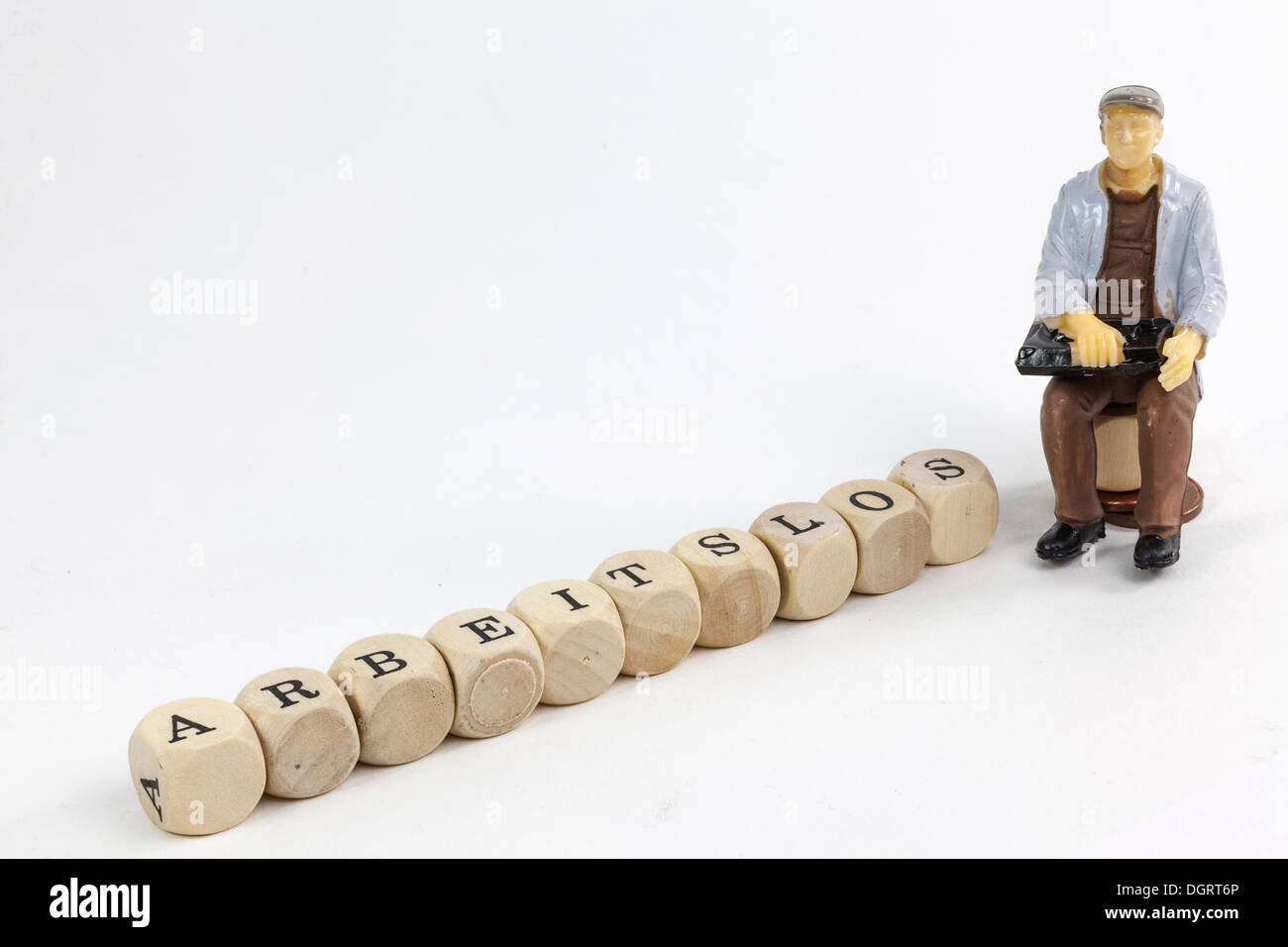 Miniature figure of an unemployed worker, letter cubes forming the word 'arbeitslos', German for 'unemployed' Stock Photo