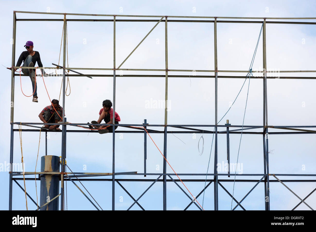 Unsecured workers assembling a scaffold, Banjar Kertabuana, Denpasar, Bali, Indonesia Stock Photo