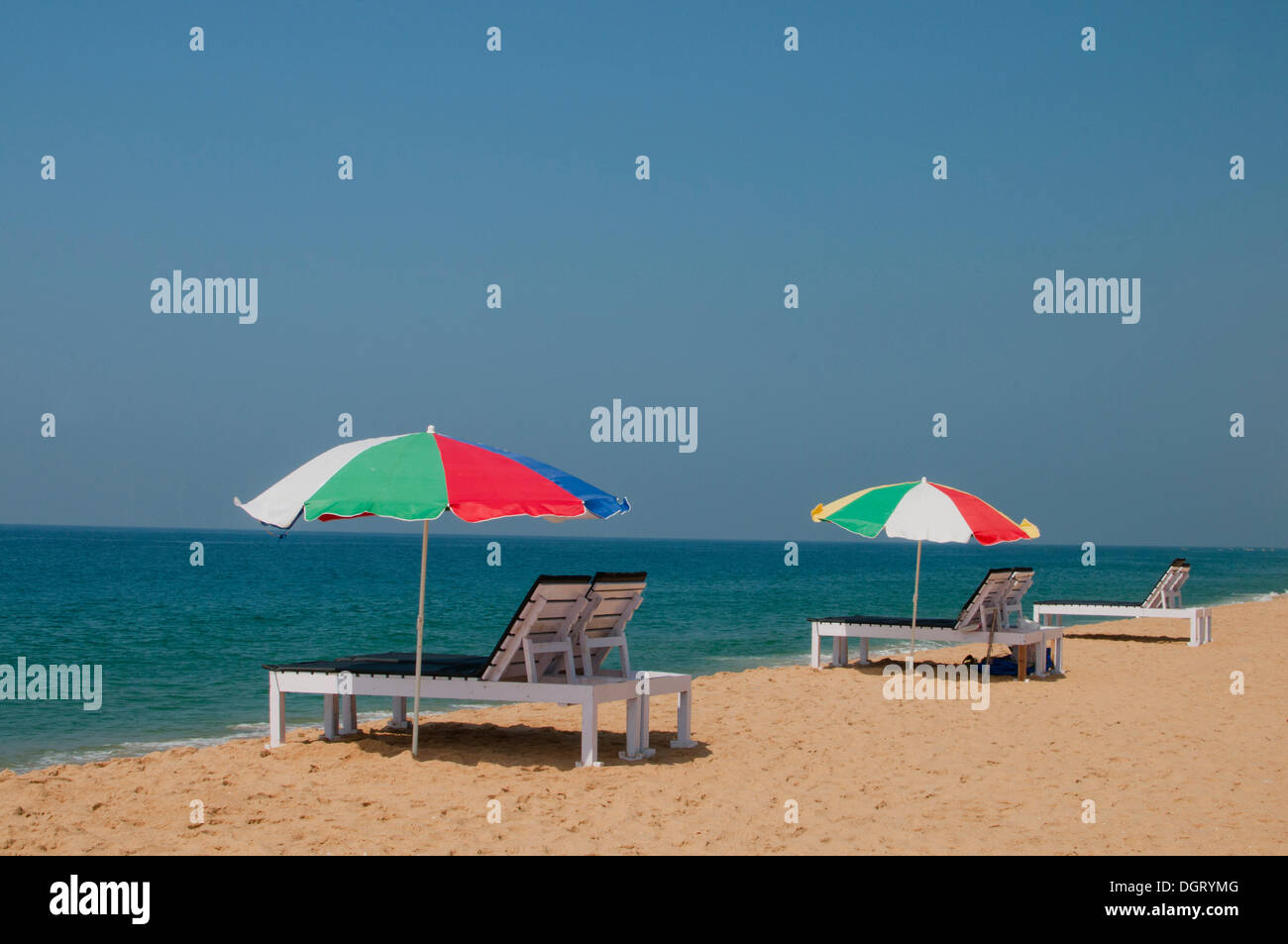 Beach chairs and parasols by the Indian Ocean, Kerala, India Stock Photo