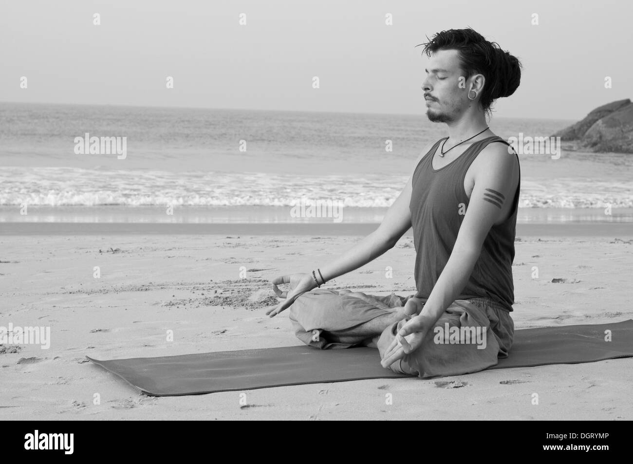 Man meditating on the beach, India Stock Photo