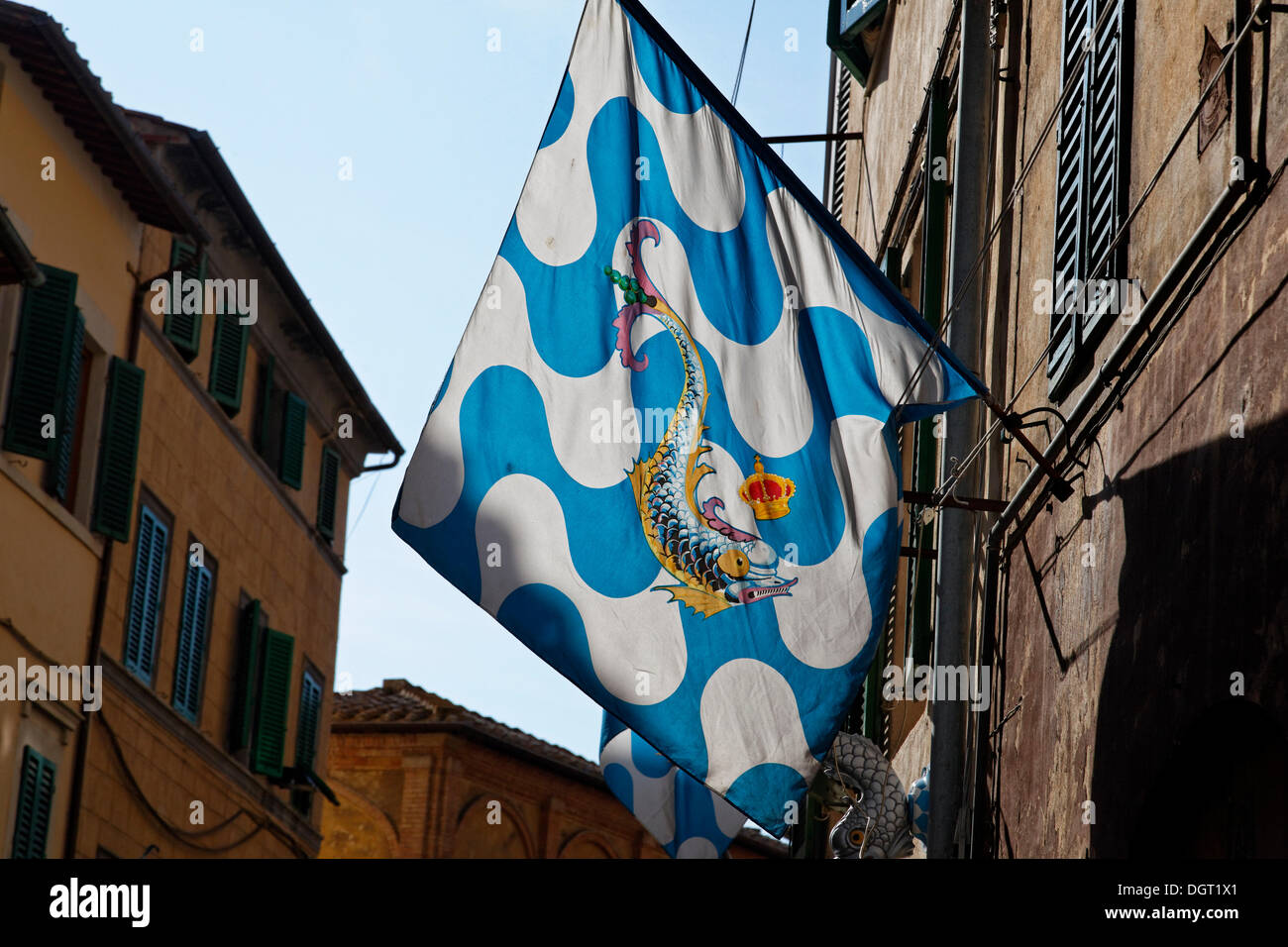 Flag of a contrada district in an alley of the historic town centre, Capitana Contrada dell'Onda, Captain Contrada of the Stock Photo